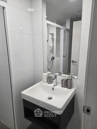 Modern bathroom with sleek sink and shower in compact space