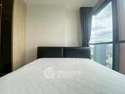 Modern bedroom with large window offering stunning city view
