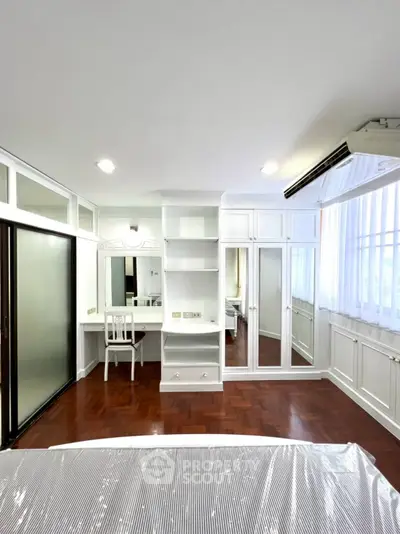 Elegant bedroom with built-in wardrobe and hardwood floors