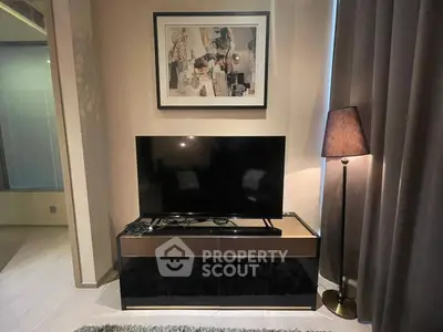 Modern living room with sleek TV stand, stylish lamp, and contemporary artwork.