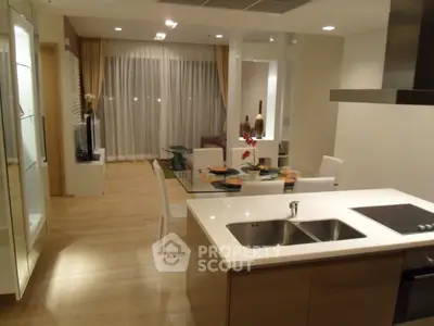 Modern open-layout kitchen and dining area with elegant decor and ambient lighting.