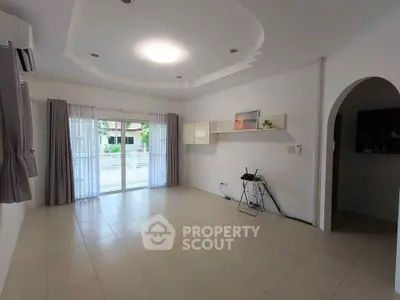 Spacious living room with modern ceiling design and large windows for natural light.