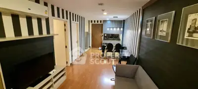 Modern living room with stylish black and white decor, featuring a cozy sofa and sleek dining area.