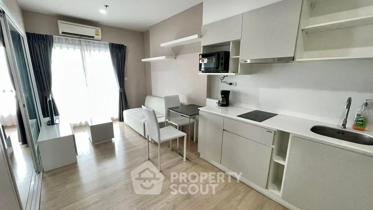 Modern open-layout studio apartment with sleek kitchen and cozy living area.