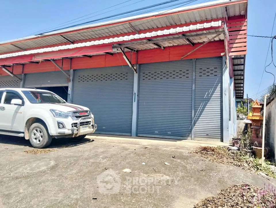 Commercial property with large garage doors and ample parking space