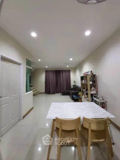 Spacious living room with modern decor and dining area, perfect for family gatherings.