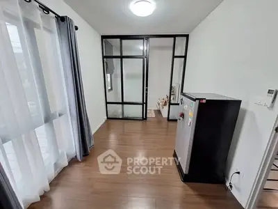 Modern interior with wooden flooring and large windows in a sleek apartment.