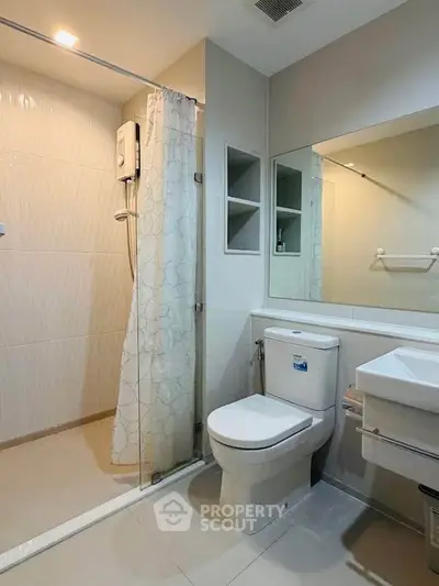 Modern bathroom with glass shower and sleek fixtures in a contemporary apartment.