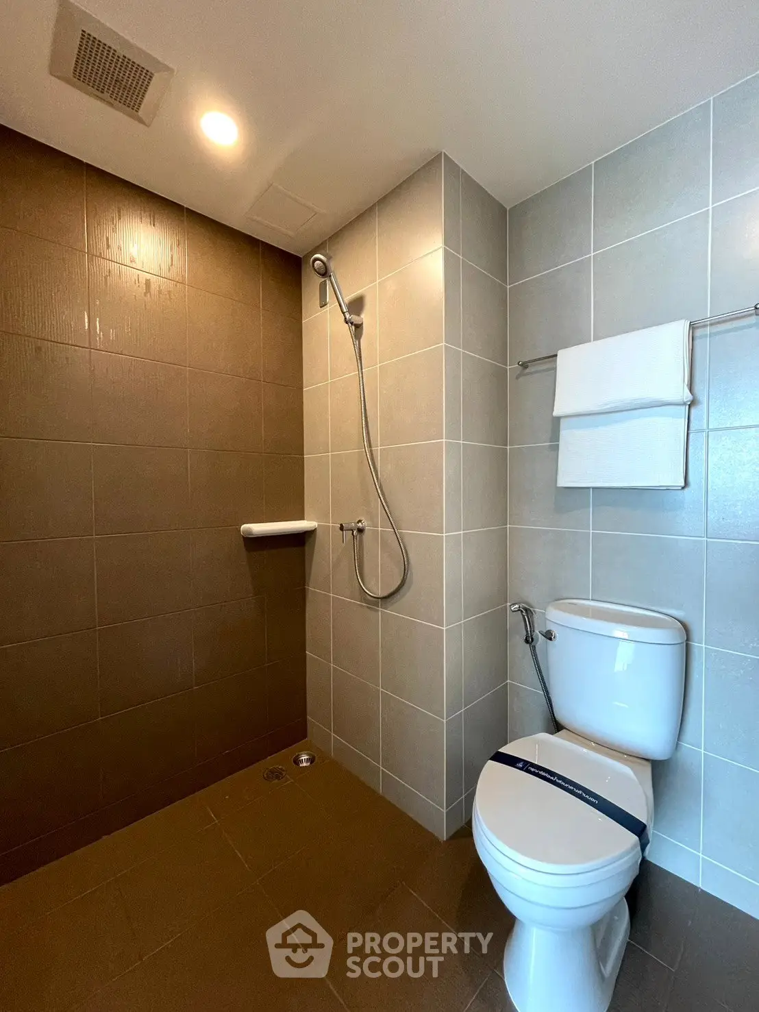 Modern bathroom with sleek shower and toilet in a contemporary real estate property.
