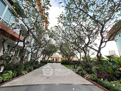 Beautiful garden pathway with lush greenery and modern building facade