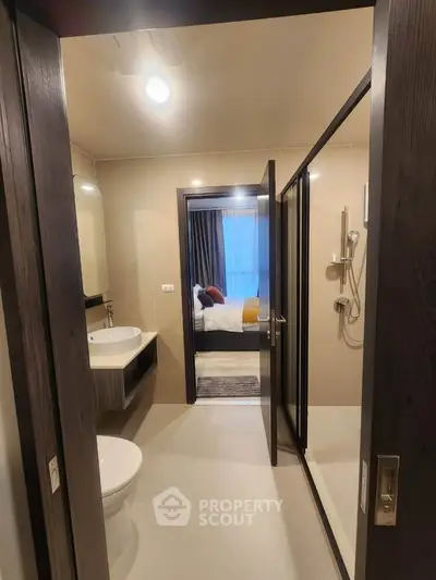 Modern bathroom with sleek design and view into cozy bedroom