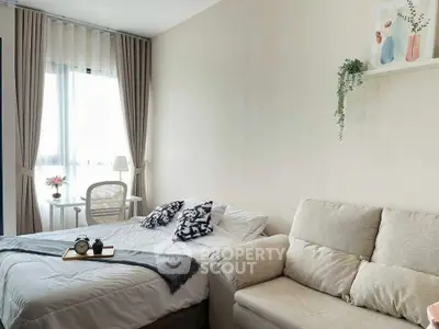 Cozy bedroom with natural light, stylish decor, and comfortable seating area.