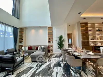 Luxurious open-plan living and dining area with high ceilings and elegant decor