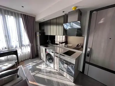 Modern kitchen with sleek appliances and natural light in a stylish apartment.