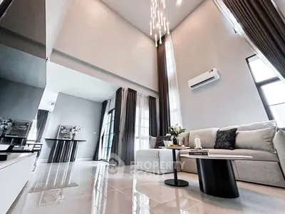 Luxurious high-ceiling living room with elegant decor and modern lighting