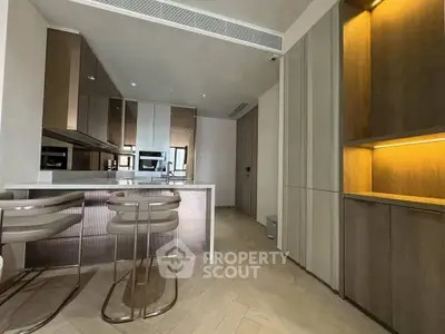 Modern kitchen with sleek cabinetry and built-in appliances, featuring a stylish breakfast bar and elegant lighting.