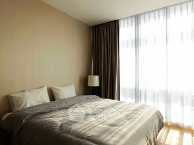 Luxurious bedroom with elegant decor and large window for natural light.