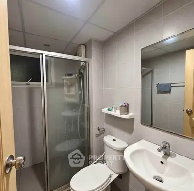 Modern bathroom with shower, sink, and toilet in a sleek design.