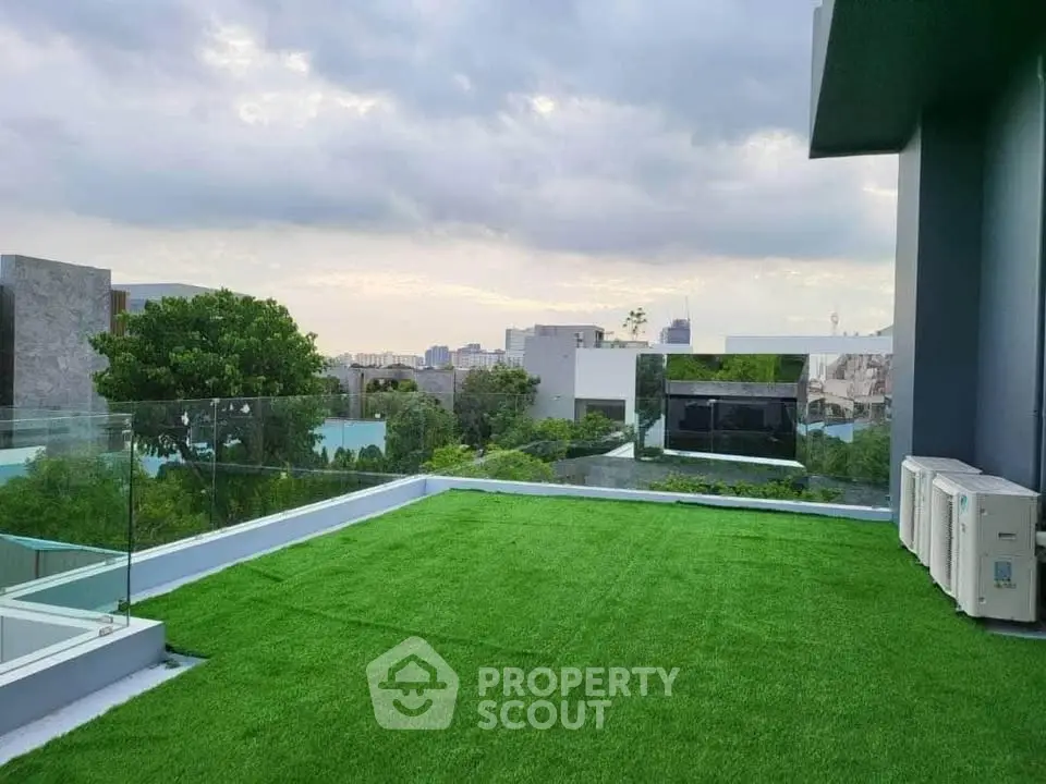 Stunning rooftop terrace with lush artificial grass and panoramic city views, perfect for relaxation and entertainment.