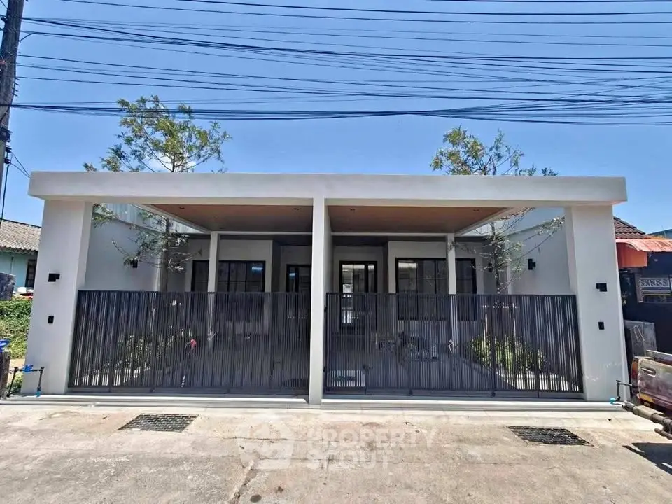 Modern duplex house with sleek design and gated entrance in a suburban neighborhood.