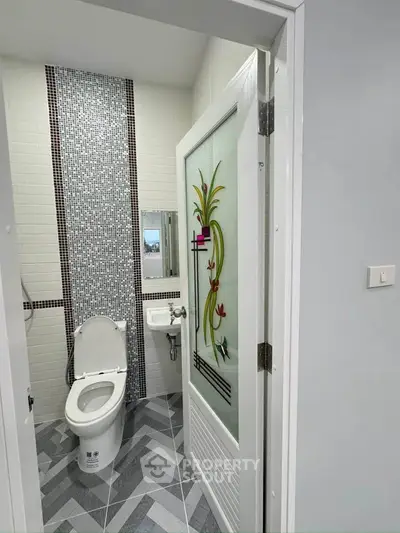Modern bathroom with stylish tile design and decorative glass door