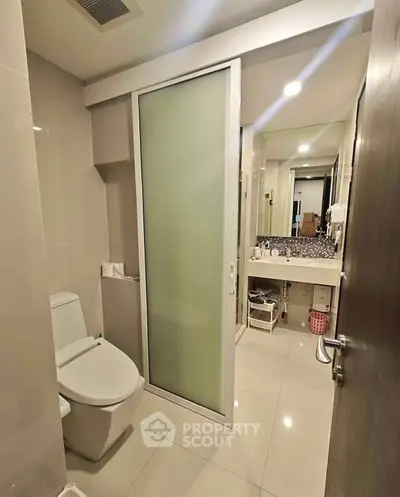 Modern bathroom with sleek design and frosted glass door
