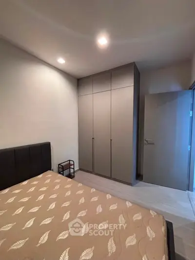 Modern bedroom with sleek wardrobe and cozy bed in minimalist design.