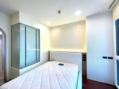 Modern bedroom with stylish design and ample natural light, featuring a comfortable bed and sleek decor.