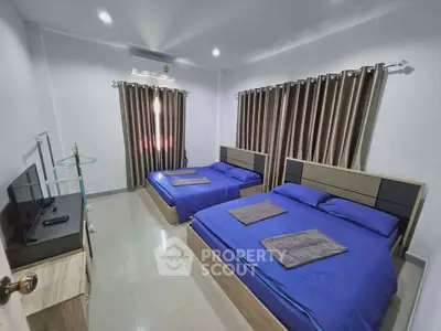 Spacious bedroom with two double beds and modern decor, perfect for comfort and relaxation.