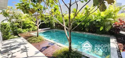 Luxurious private pool surrounded by lush greenery in a serene backyard setting.