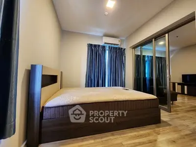 Spacious bedroom with modern decor and large windows for natural light.