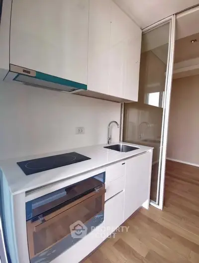 Modern kitchen with sleek white cabinets and built-in oven