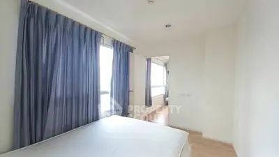 Spacious bedroom with large windows and blue curtains