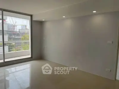 Spacious modern living room with large windows and city view, perfect for urban living.