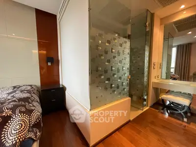 Modern bedroom with glass-enclosed shower and elegant decor