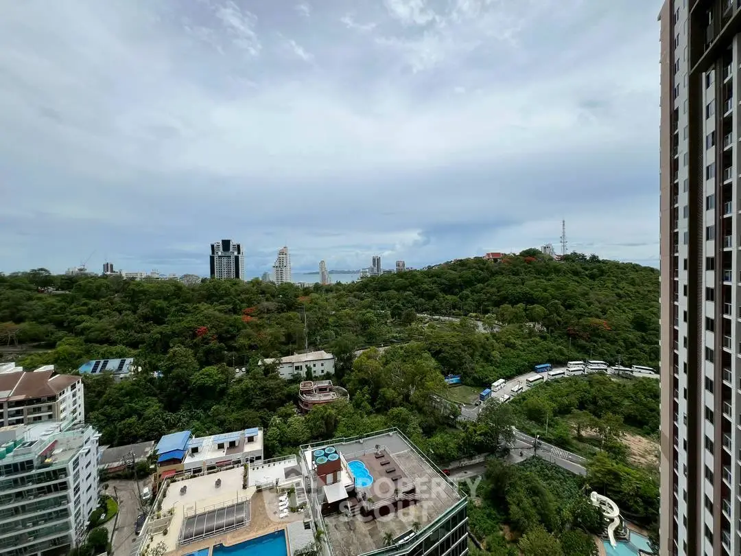 Stunning high-rise view overlooking lush greenery and cityscape, perfect for urban living.