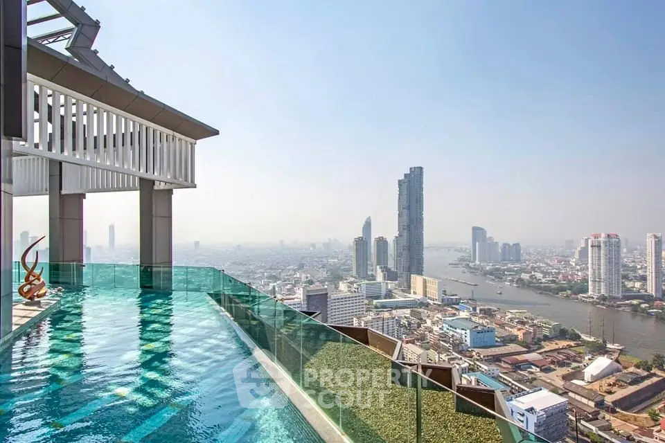 Stunning rooftop pool with panoramic city and river views in a luxury high-rise building.