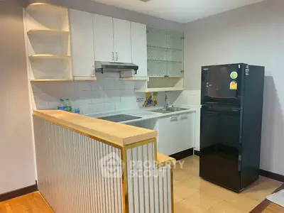 Charming kitchen with modern appliances and stylish cabinetry in cozy apartment.