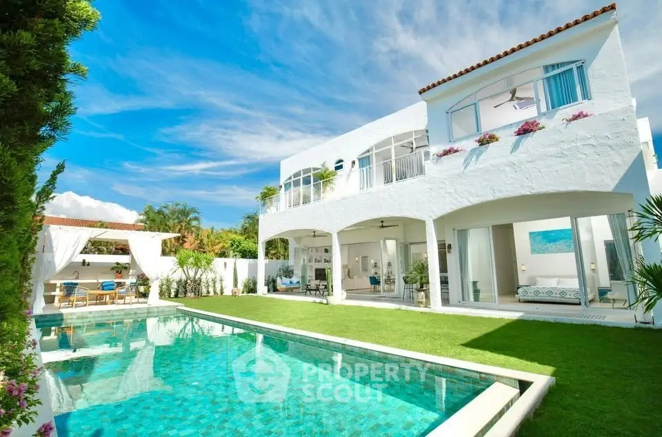 Luxurious white villa with pool and lush garden, perfect for serene living.