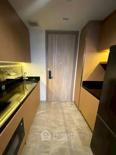 Modern kitchen with sleek cabinetry and built-in appliances in a compact layout.