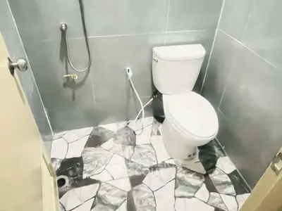 Modern bathroom with sleek gray tiles and unique patterned flooring.