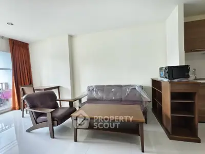 Modern living room with sleek furniture and open kitchen layout, perfect for urban living.