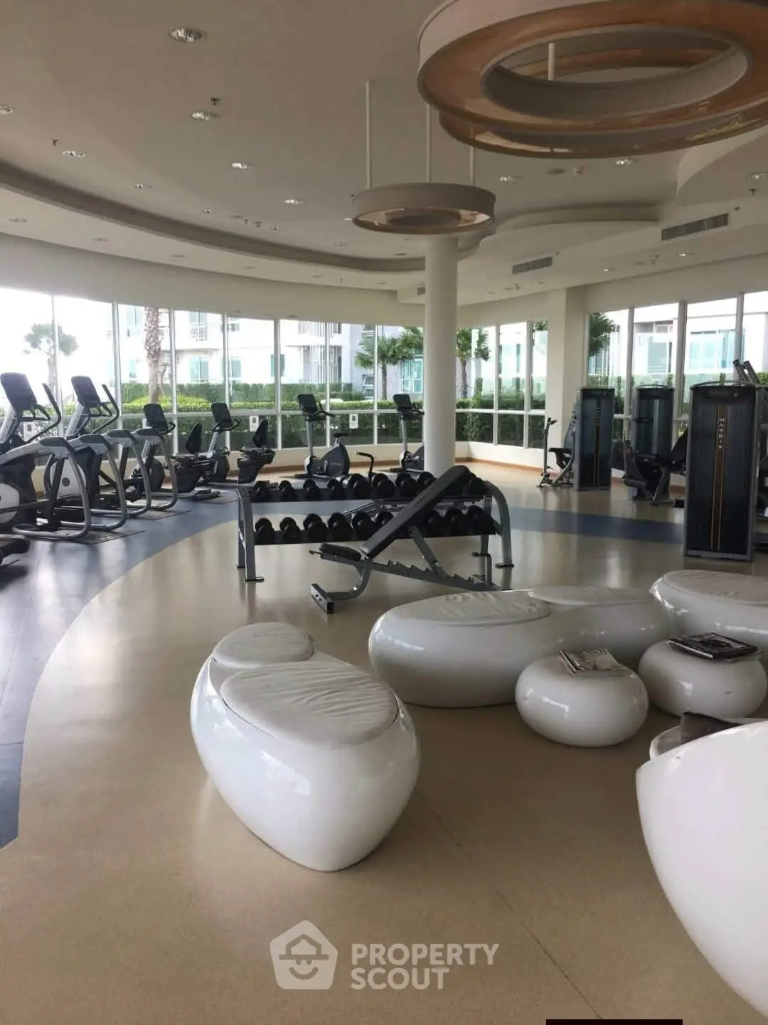 Luxurious modern gym with state-of-the-art equipment and stylish seating area.