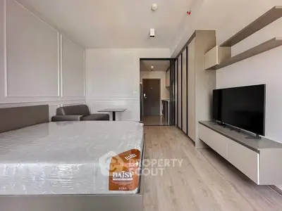 Modern bedroom with sleek design, featuring a comfortable bed, TV, and stylish decor in a contemporary apartment.