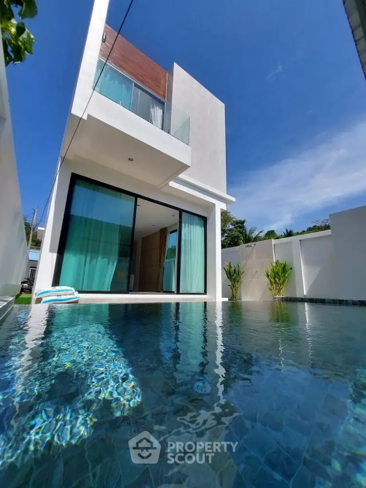 Modern luxury villa with private pool and sleek architectural design under clear blue sky.
