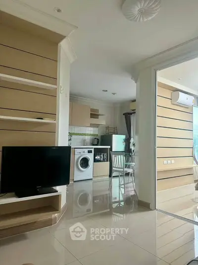 Modern open-plan living room with kitchen featuring sleek appliances and stylish decor.