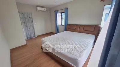 Spacious bedroom with large windows and modern furnishings