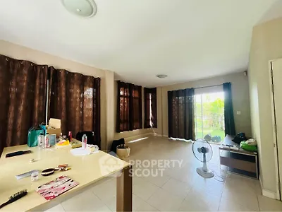 Spacious living room with large windows and garden view, ideal for modern living.
