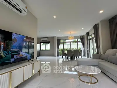 Spacious modern living room with elegant dining area and large windows for natural light.