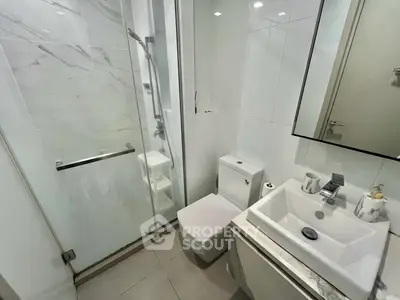 Modern bathroom with sleek design, featuring a glass shower and contemporary fixtures.